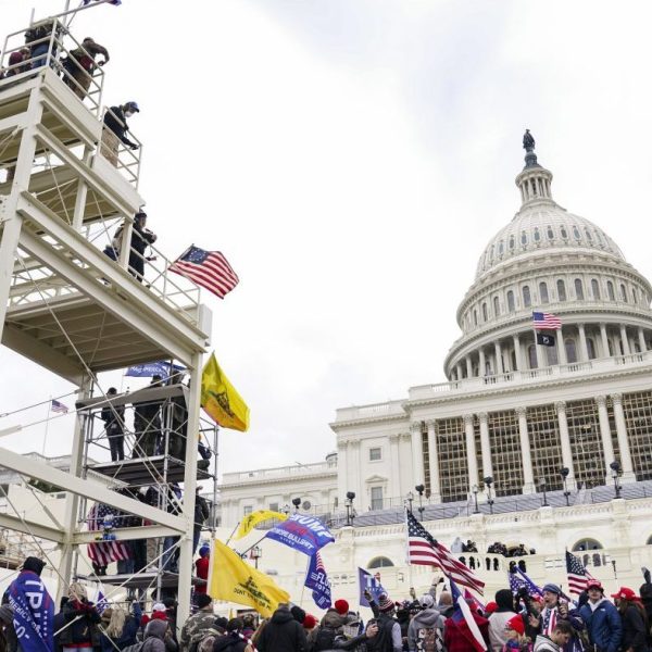 FILE - Violent insurrectionists loyal to President Donald Trump breach the U.S. Capitol in Washington, Jan. 6, 2021. John Banuelos, of Summit, Ill., who was accused of climbing scaffolding and firing a gun in the air during the riot was arrested Friday, March 8, 2024. Banuelos was charged with several felony and misdemeanor counts, including firearm charges. (AP Photo/John Minchillo, File)
