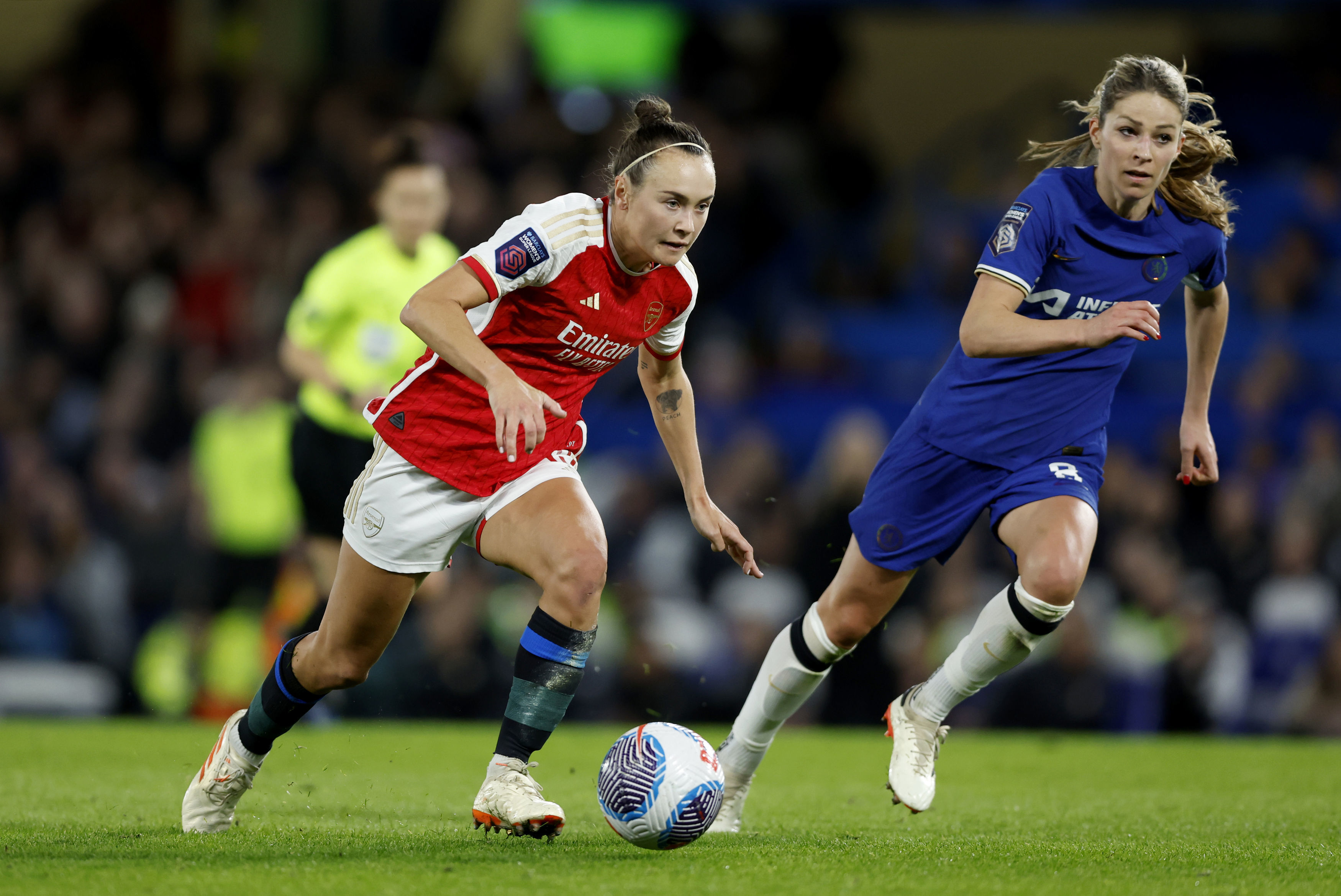 Arsenal's Caitlin Foord, left, and Chelsea's Melanie Leupolz battle for the ball during the Women's Super League soccer match between Chelsea and Arsenal at Stamford Bridge, London, Friday March 15, 2024. (Nigel French/PA via AP)