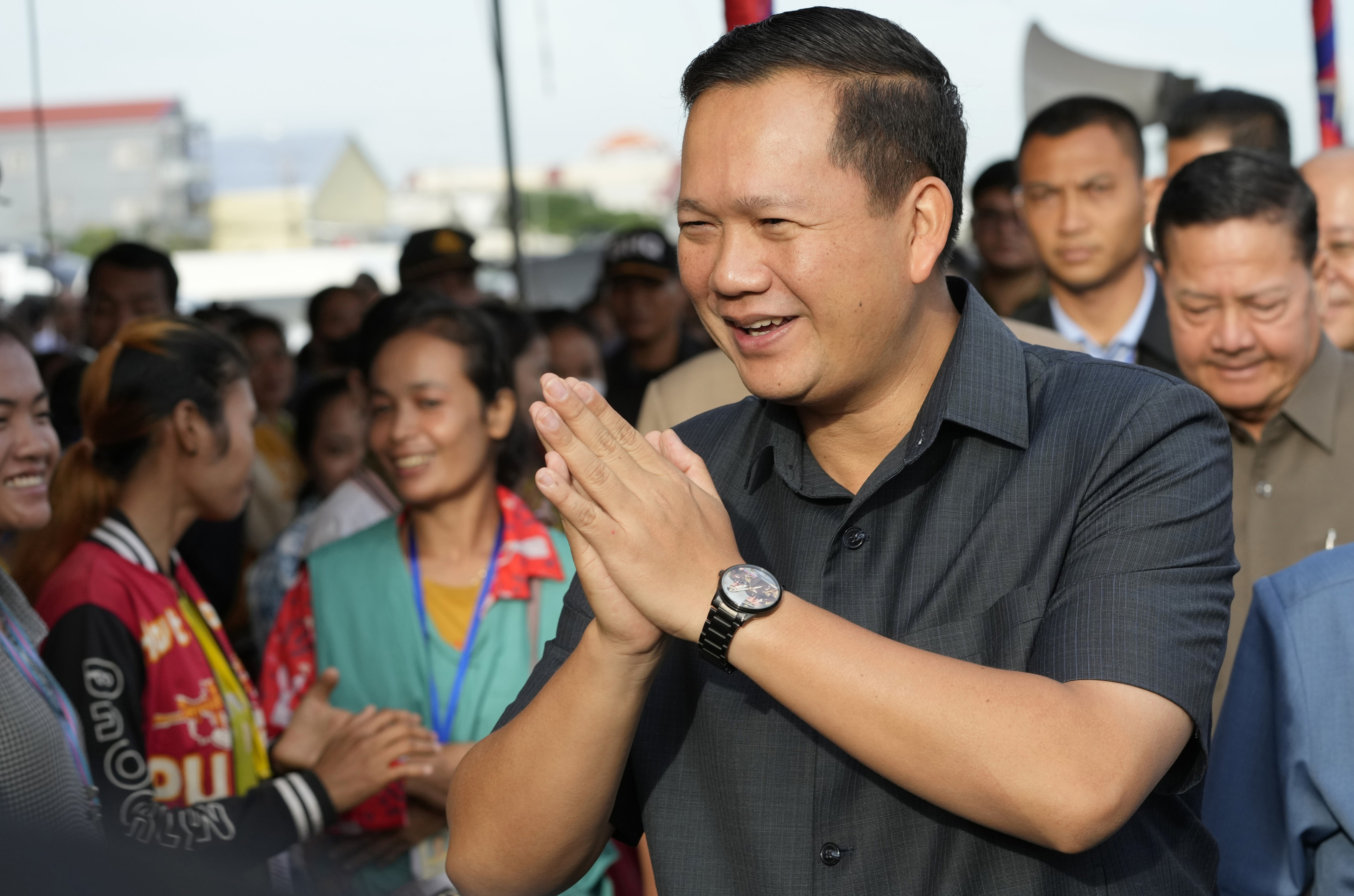 FILE - Cambodian Prime Minister Hun Manet greets garment workers at Prey Speu village outside Phnom Penh, Cambodia, on Aug. 29, 2023. Manet has ordered a ban on musical horns, after videos posted on social media showed people dancing on roads and roadsides as passing trucks blasted rhythmic little tunes. Hun Manet called on the Ministry of Public Works and Transportation and police to immediately take action against any vehicle whose normal horn has been replaced by a tune-playing one by ripping it out and restoring the standard honking type. (AP Photo/Heng Sinith, File)
