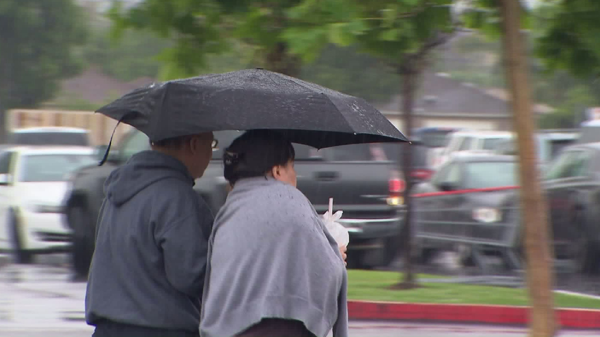 A couple walks under an umbrella during a rain storm in Fullerton in this file image.